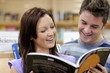 Cheerful couple reading a book in the science department Cheerful couple reading a book in the science department