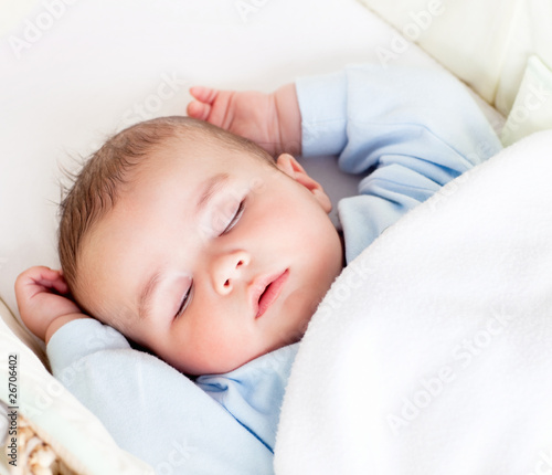 Photo: Portrait of a peaceful baby sleeping in his cradle at home Portrait of a peaceful baby sleeping in his cradle at home