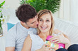Handsome man kissing her girlfriend after giving her a present