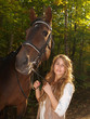 A girl and a horse in the autumn forest