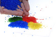 Farbiges Kunststoffgranulat mit Hand