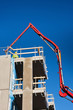 Huge concrete pump with tall arm pumping conrete on top of the b