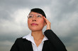Asian business woman under a cloudy sky.