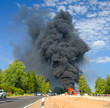 truck in fire with black smoke on the road