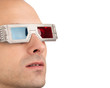 Young man watching television in 3D wearing red and blue glasses Young man watching television in 3D wearing red and blue glasses