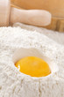 egg yolk in flour, rolling pin ang sieve on background egg yolk in flour, rolling pin ang sieve on background