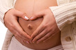 Heart shaped hands of pregnant woman