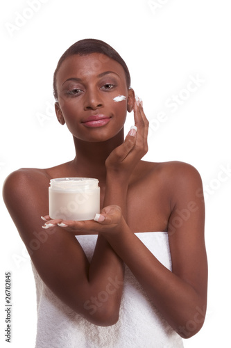 Photo: Black woman wrapped in towel moisturizing face Black woman wrapped in towel moisturizing face