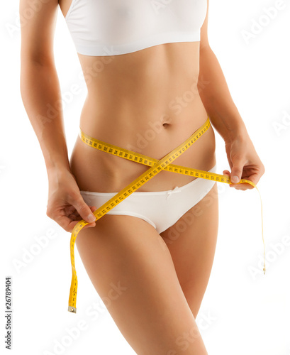 Photo: Woman measuring her slim body isolated on white Woman measuring her slim body isolated on white