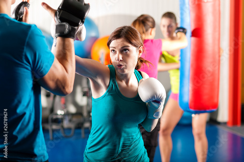 Photo: Female kick boxer with trainer in sparring Female kick boxer with trainer in sparring