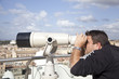 uomo guarda il panorama dalla terrazza con il binocolo