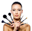 Beautiful woman with makeup brushes - isolated