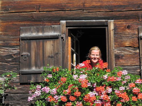 Foto: Frau an Fenster an altem Bauernhaus Frau an Fenster an altem Bauernhaus