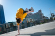 Teenage hip-hop girl dancing over city landscape