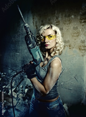 Foto: Beautiful blond woman with heavy drill in her hands Beautiful blond woman with heavy drill in her hands