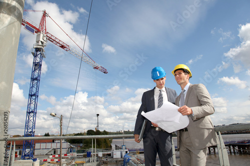Foto: Businessmen checking plan on construction site Businessmen checking plan on construction site
