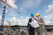 Architects checking plan on construction site Architects checking plan on construction site
