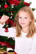 Photo: Young girl with bell sit near Christmas tree. Young girl with bell sit near Christmas tree.