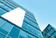 blue glass wall with blank placard of skyscraper