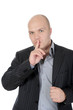 Photo: young businessman holding a finger to his mouth. young businessman holding a finger to his mouth.