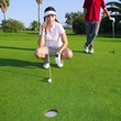golf young woman looking and aiming the hole golf young woman looking and aiming the hole