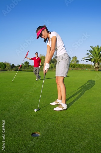 Photo: golf woman player green putting hole golf ball golf woman player green putting hole golf ball