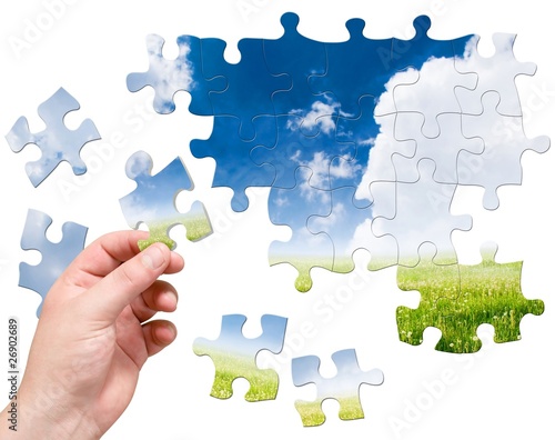 Photo: puzzle in hand on landscape background puzzle in hand on landscape background