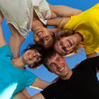 Below view of joyful teens embracing and looking at camera with