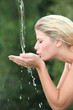 Blond woman drinking water from fountain
