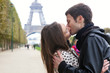 Photo : Young romantic couple kissing near the Eiffel Tower in Paris Young romantic couple kissing near the Eiffel Tower in Paris