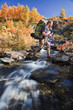 Wanderer beim Queren eines Baches im Herbst Wanderer beim Queren eines Baches im Herbst