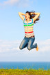 Beautiful young woman jumping up in the air smiling