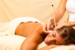 Foto: Frau mit Ohrenkerze und Edelstein Massage Frau mit Ohrenkerze und Edelstein Massage