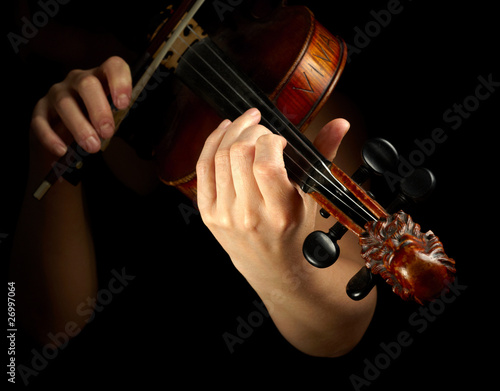 Photo: Musician playing violin isolated on black Musician playing violin isolated on black