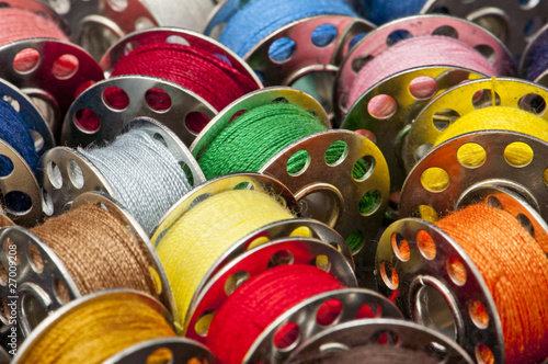 Photo: Colorful spools of yarn in a close-up Colorful spools of yarn in a close-up