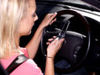 Young Woman Driving Texting on Mobile Telephone. Model Released