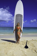 teenager standing with her paddleboard on a hawaii beach teenager standing with her paddleboard on a hawaii beach