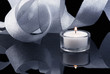 Decoration with burning candle and shining ribbon on black Decoration with burning candle and shining ribbon on black