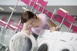 Young woman chooses washing machine in shopping mall, Voronezh
