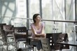 Young woman sits in food hall of shopping mall, Voronezh