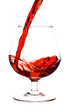 Red wine being served into a glass cup on a white background