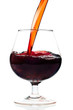 Red wine being served into a glass cup on a white background