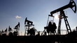 working oil pumps silhouette against sun