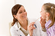 Female doctor examining child with tongue depressor Female doctor examining child with tongue depressor