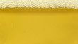 Golden cold beer being poured into glass, close-up