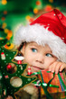 Photo: Happy small girl in santa hat have a christmas Happy small girl in santa hat have a christmas