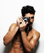 Photo: Naked man taking a photo with his digital camera against white Naked man taking a photo with his digital camera against white