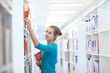 pretty young college student in a library (shallow DOF; color to