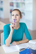 pretty young college student in a library (shallow DOF; color to