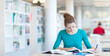 pretty young college student in a library (shallow DOF; color to
